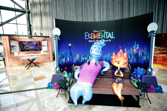 A image of Elemental characters Wade and Ember on a bench for fans to take photos with.